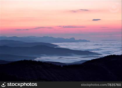 Sunrise at foggy mountain valley. Demerdzhi area, Crimea, Ukraine