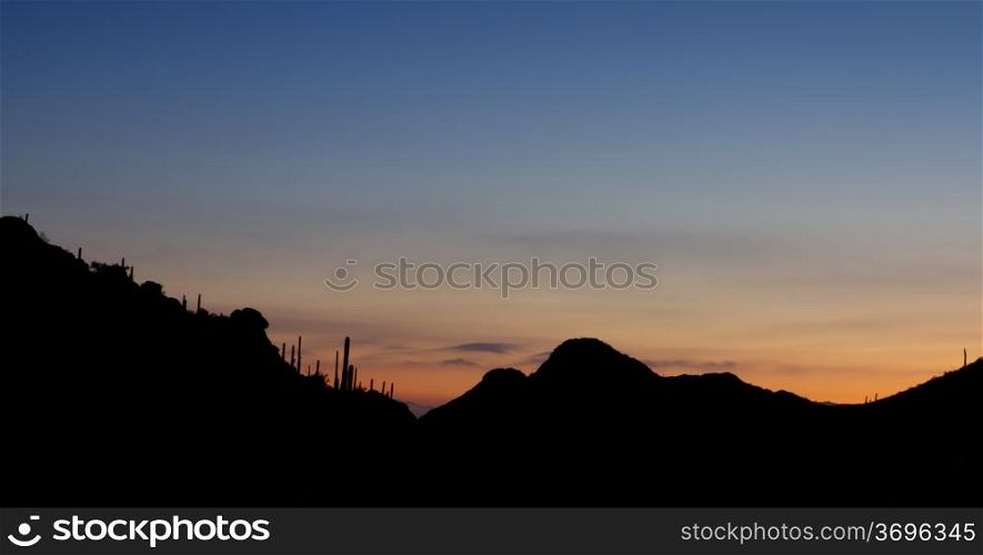 Sunrise at Gates Pass in Tucson Mountain Park, looking back toward city of Tucson, Arizona; copy space above;
