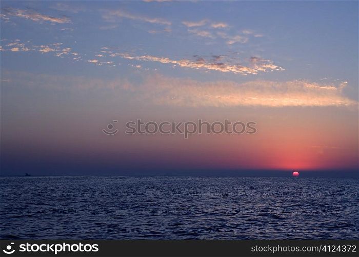 Sunrise at mediterranean sea. Red horizon, blue water