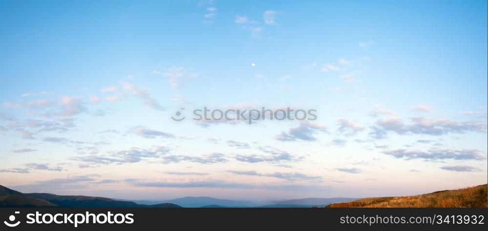 Sunrise blue sky panorama with cloud and Moon over Carpathian mountain. Two shots stitch image.