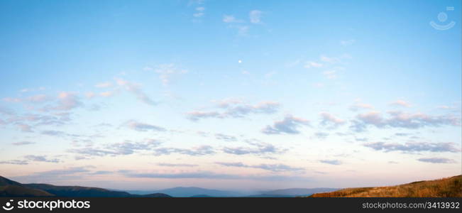 Sunrise blue sky panorama with cloud and Moon over Carpathian mountain. Two shots stitch image.