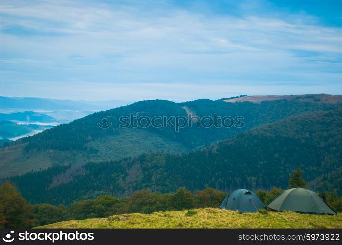 Sunrise in misty morning and tents on Carpathian mountains in summer. Sunrise in misty morning