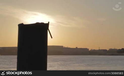 Sunrise in Saint Petersburg with big dark pipe. Sun reflection on water.