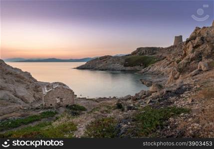 Sunrise in the bay at Ile Rousse in Corsica with an abandoned building in the foreground and a Genoese tower and mountains of desert des agriates in the background