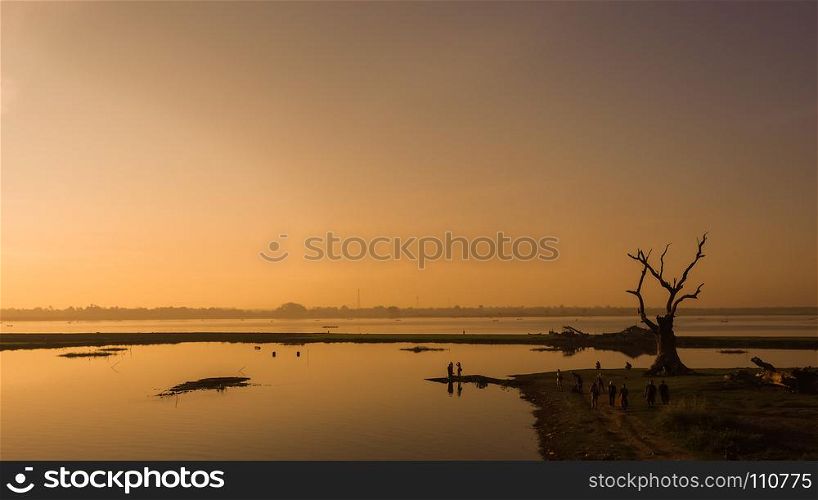 Sunrise in U Bein bridge in Amarapura Myanmar (Burma). at river side in Amarapura Mandalay, Myanmar with wonderful sun light in the morning