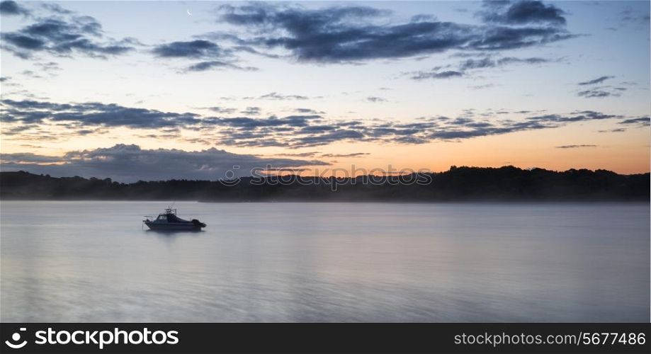 Sunrise landscape of boat on calm lake