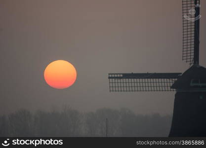 sunrise misty winter morning with windmill