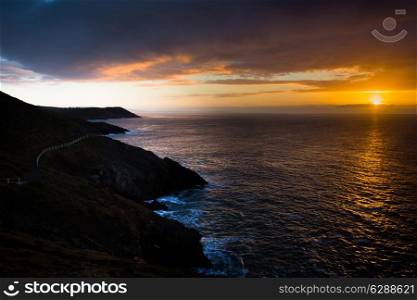Sunrise near Langland Bay, on the Gower Peninsula, South Wales, with the Wales Coast path snaking across the cliffs.