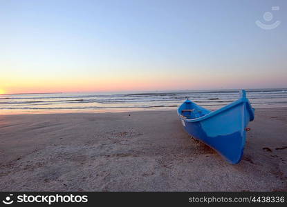 Sunrise on beach and blue boat