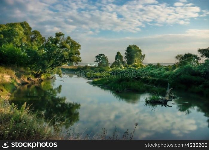 Sunrise on river with clouds above water