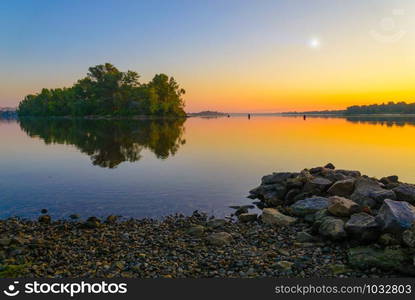 Sunrise on the Dnieper River in Kiev during summer. Stones in the foreground.