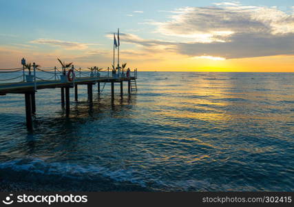 Sunrise on the sea with a pier in Kemer, Turkey