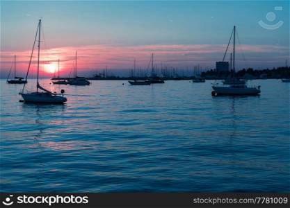 Sunrise on the seashore. In the silhouette of the ships in the harbor. Selective focus. High-quality photo. Sunrise on the seashore. In the silhouette of the ships in the harbor. Selective focus 