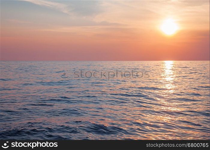 Sunrise or sunset over calm sea, pastel colors