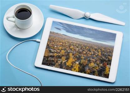 sunrise over city of Fort Collins and Front Range of Rocky Mountains in northern Colorado in a fall scenery, reviewing an aerial image on a digital tablet