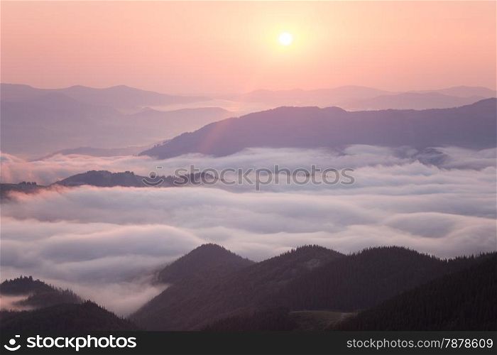 Sunrise over cloudy mountain ridge