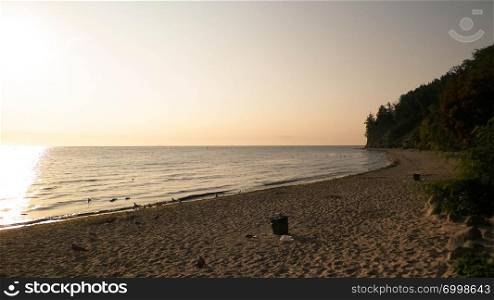Sunrise over Orlowski Cliff and a beautiful sandy beach by the Baltic Sea, Poland. Polish nature, vacations and tourism concept.. Sunrise over Orlowski Cliff and a beautiful sandy beach by the Baltic Sea, Poland.