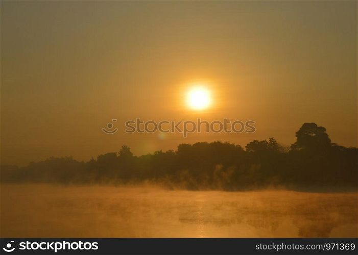 Sunrise over the lake with fog on the water near Pune