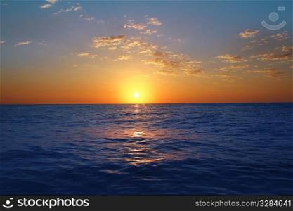 Sunrise sunset in ocean blue sea horizon glowing orange golden sun