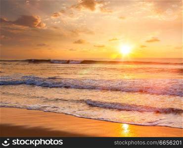 Sunrise with rising sun on morning beach. With lens flare and light leak. Sunrise on beach