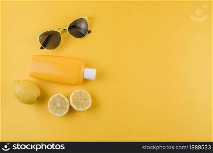 sunscreen lotion lemons sunglasses yellow background. Resolution and high quality beautiful photo. sunscreen lotion lemons sunglasses yellow background. High quality and resolution beautiful photo concept