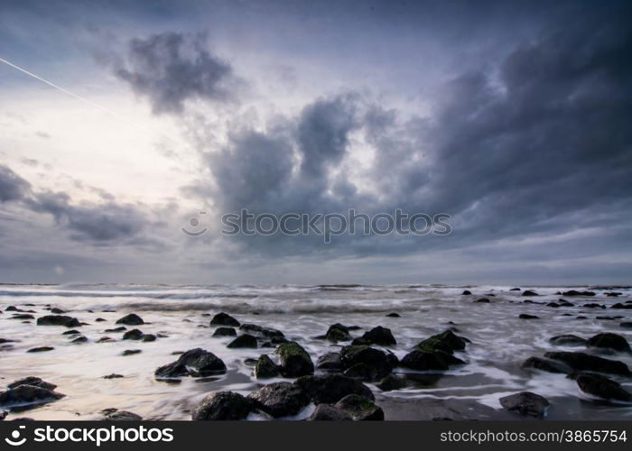 Sunset above Dutch beach with dramatic sky