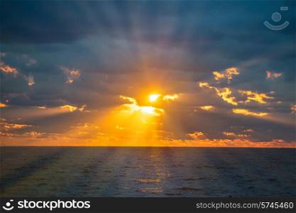 Sunset above sea, with waves, dramatic clouds on the sky