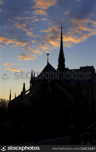 Sunset above the Notre Dame de Paris cathedral, black silhouette on a dusk sky