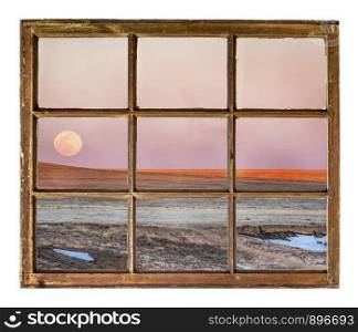 Sunset and moon rise over prairie as seen from a vintage sash window