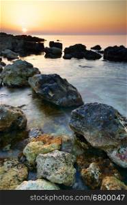 Sunset and rocks on the sea. Nature composition.