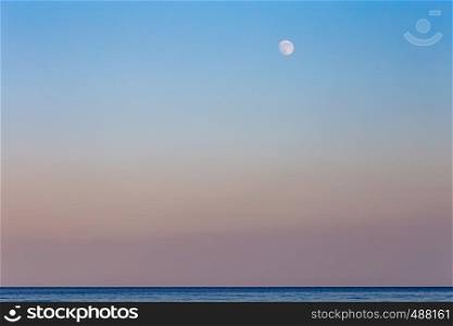 sunset and the moon on the warm Sicilian sea in late summer