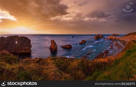 Sunset Arnia Beach  Spain, Atlantic Ocean  coastline landscape.