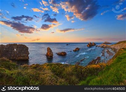 Sunset Arnia Beach (Spain, Atlantic Ocean) coastline landscape. Four shots stitch panorama.