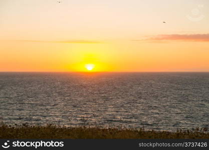 Sunset as seen from the top of a hill overlooking the sea