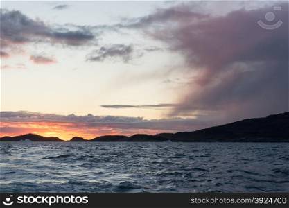Sunset at arctic coast. Sunset at arctic coast with cloudscape on Disko Island in Greenland
