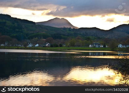 Sunset at Loch Ard. sunset behind a hill with reflections in Loch Ard