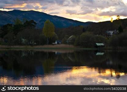 Sunset at Loch Ard. sunset behind a hill with reflections in Loch Ard