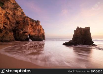 Sunset at rocky coastline of Atlantic ocean, Algarve, Portugal