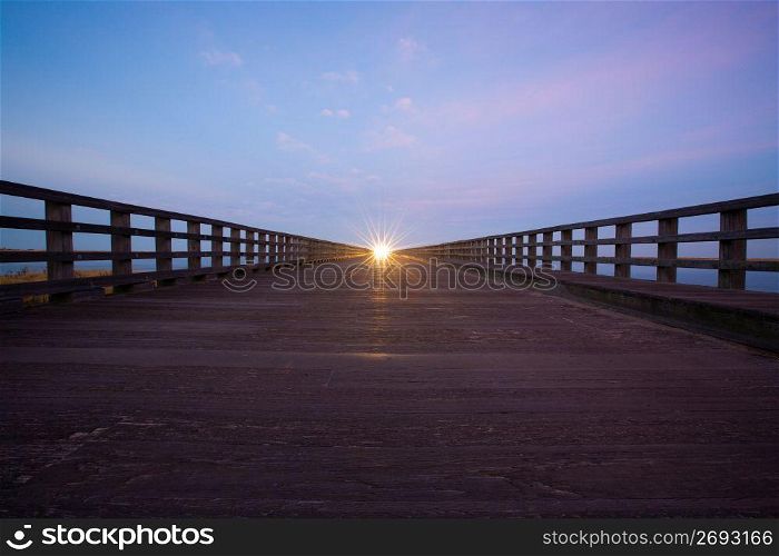 Sunset at the end of a bridge