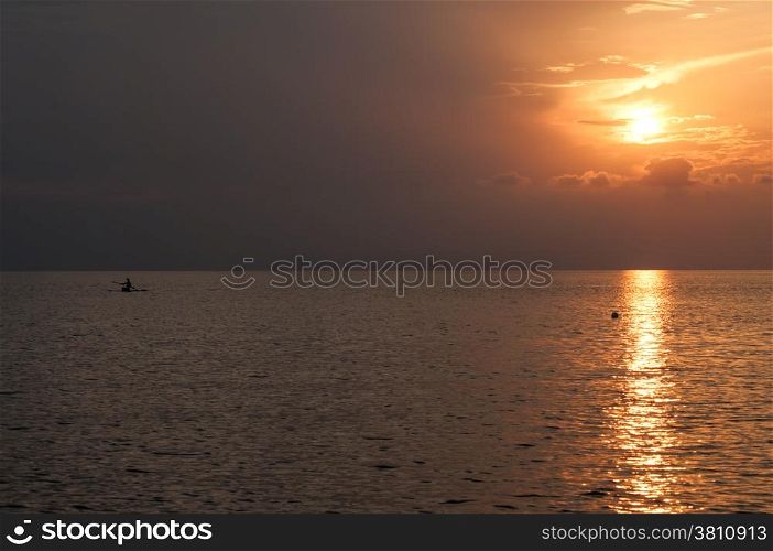 Sunset behind clouds over sea water as background