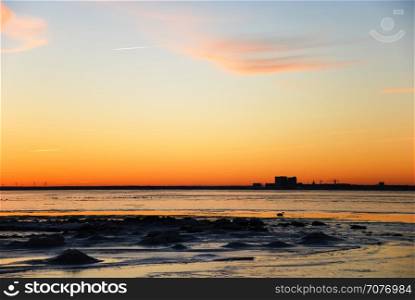 Sunset by the coast of the Baltic Sea with the skyline of the city Kalmar in the horizon
