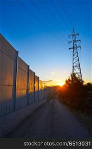 Sunset in a track with electric tower and concrete. Sunset in a track with electric tower and concrete wall