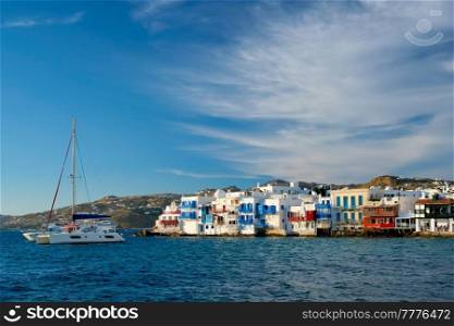 Sunset in Mykonos island, Greece with yachts in the harbor and colorful waterfront houses of Little Venice romantic spot on sunset and cruise ship. Mykonos townd, Greece. Sunset in Mykonos, Greece, with cruise ship and yachts in the harbor