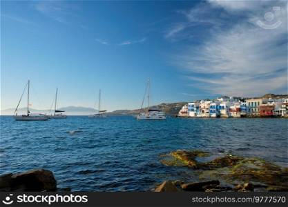 Sunset in Mykonos island, Greece with yachts in the harbor and colorful waterfront houses of Little Venice romantic spot on sunset and cruise ship. Mykonos townd, Greece. Sunset in Mykonos, Greece, with cruise ship and yachts in the harbor