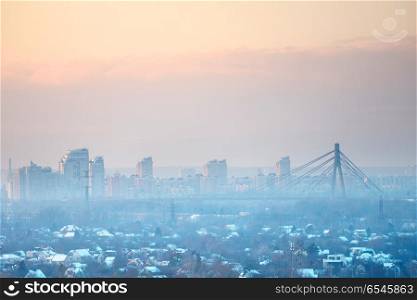 Sunset in the city. Panoramic view of sunset in the city with cable-braced bridge and buildings