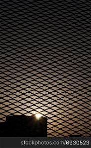 Sunset in the city through a fence