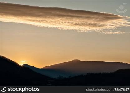 Sunset in the mountain landscape with sunny beams and golden sky. Sunset in the mountain landscape. Sunset in the mountain landscape