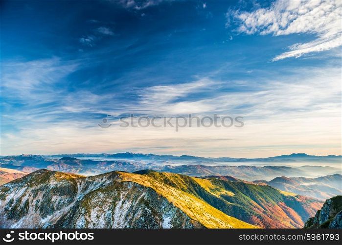 Sunset in the mountains. Landscape with hills, blue sky and clouds