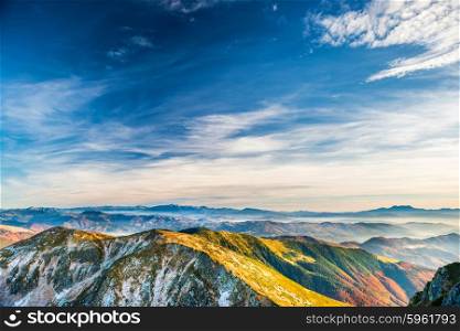 Sunset in the mountains. Landscape with hills, blue sky and clouds