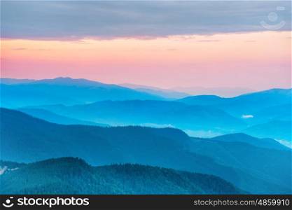 Sunset in the mountains with hills and dramatic colorful sky